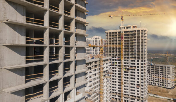 Aerial view at construction site on the sunset. Tall buildings and construction cranes.